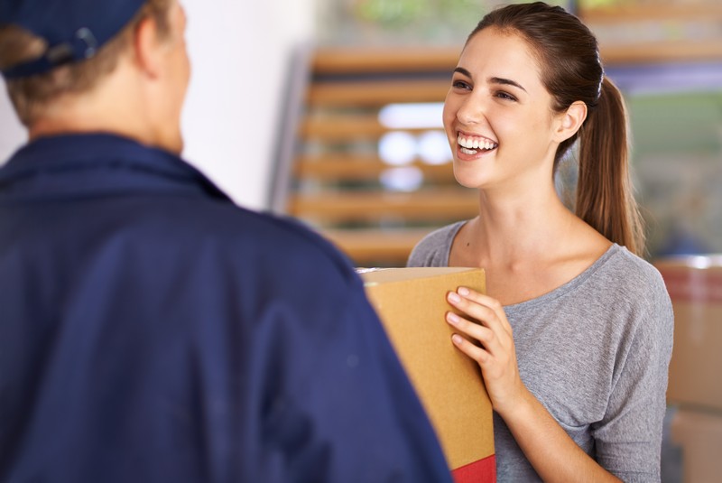 Shot of a courier making a delivery to a happy customer.